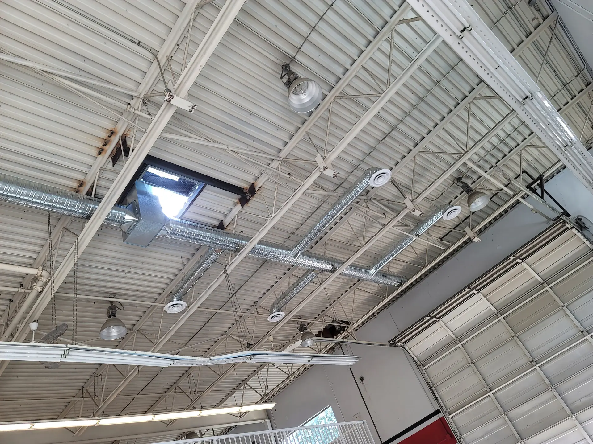 Round ventilation ductwork running across a warehouse ceiling