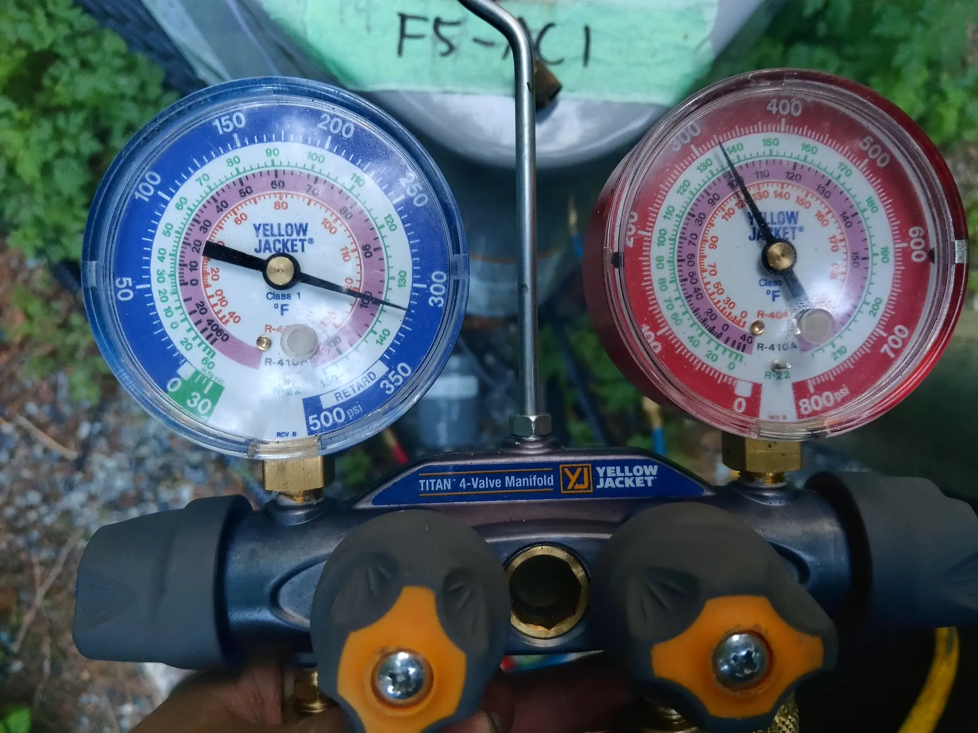 Technician with refrigerant gauges on a service call